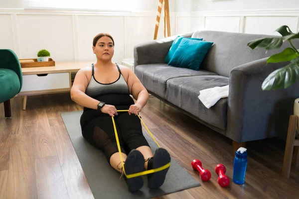 Motivation is key. Beautiful big woman stretching and exercising with a resistance band