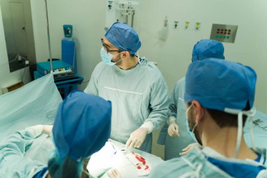 Tıbbi ekip ekrana bakıyor ve hasta bir hastaya acil ameliyat yaparken teknolojiyi kullanıyor.