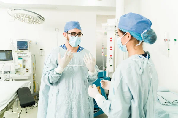 医生护士帮助外科医生戴上手套和刷子到医院做手术 — 图库照片