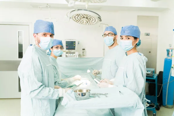 在手术室工作时 医生戴着外科口罩和蓝色刷子进行眼神交流 — 图库照片