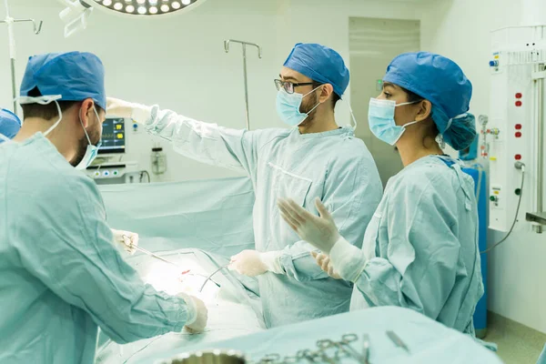 在医院为病人做手术的外科医生和护士 — 图库照片
