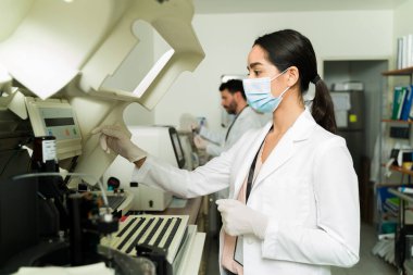 Tıbbi teşhis. Güzel bayan teknisyen kan örneği alıyor ve laboratuvar testi yapıyor. 