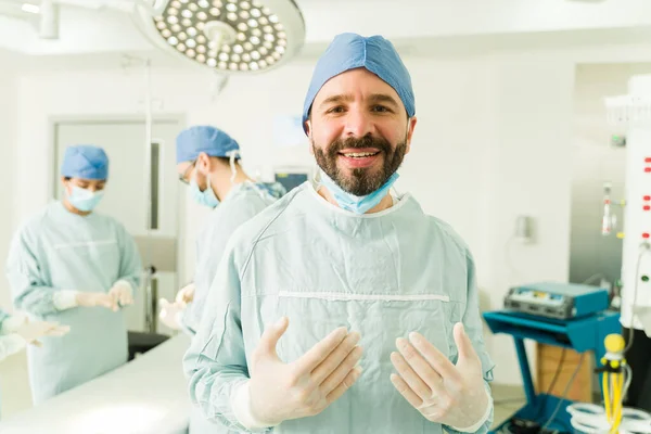 Ameliyata Başlamadan Önce Ameliyat Önlüğü Eldiven Giyerek Gülümseyen Yakışıklı Bir — Stok fotoğraf