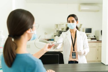 Analiz laboratuarında çalışan ve hastalara tıbbi sonuçlar veren profesyonel bir teknisyen.