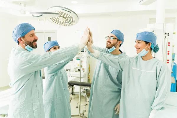 成功的医护人员在手术室里高居榜首 外科医生 医生和护士庆祝手术结束 — 图库照片