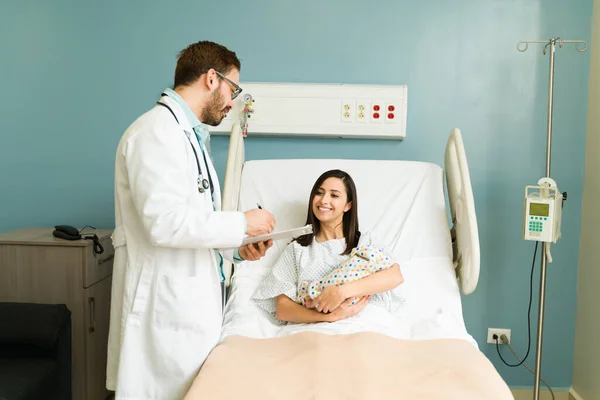 Mutlu Doktor Hastane Yatağında Dinlenirken Yeni Doğmuş Bebeğini Taşıyan Genç — Stok fotoğraf