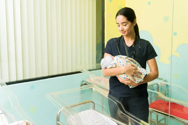 Hispanische Attraktive Krankenschwester Überprüft Ein Schlafendes Neugeborenes Kinderzimmer — Stockfoto