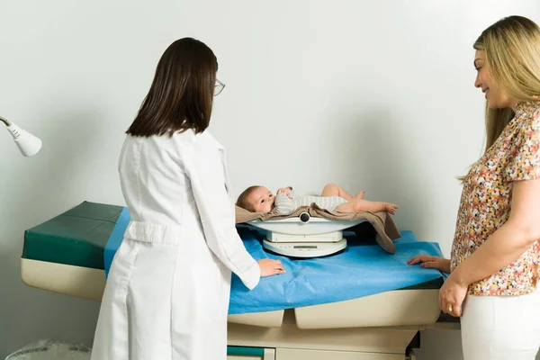 Rear View Pediatrician Weighing Healthy Baby Caucasian Mom Bringing Her — Zdjęcie stockowe