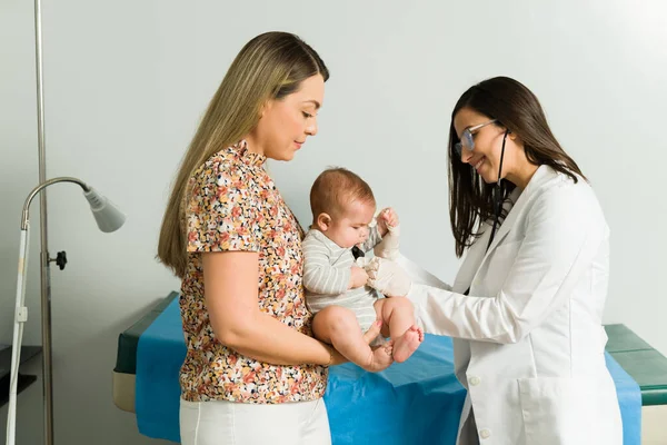 漂亮的儿科医师用听诊器来观察一个可爱婴儿的心率 — 图库照片