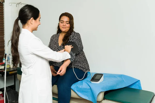 幸せな女性心臓科医は 診察のために病気の女性患者の血圧をチェックします — ストック写真