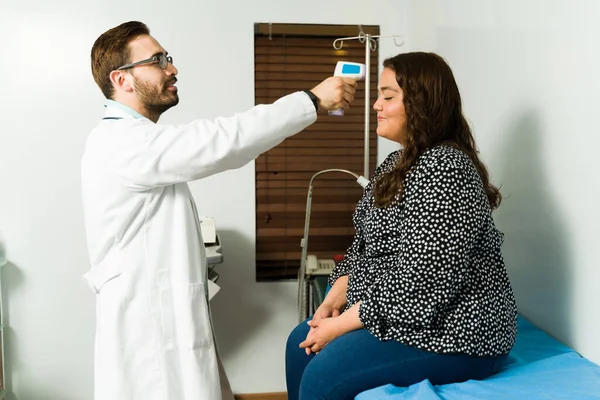 Lächelnder Arzt Mit Einem Berührungslosen Laserthermometer Einen Zufriedenen Patienten Seinem — Stockfoto