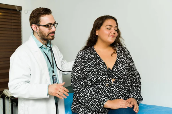 30 'lu yaşlardaki bir doktor, bir kadına sağlıklı olduğunu söylüyor. Mutlu kadın sağlık kontrolü yaptırıyor. 