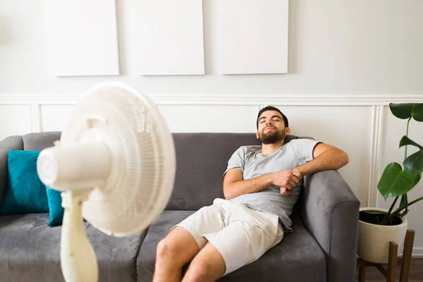 Relaxed Man Resting Sofa Front Electric Fan Because Hot Weather — Stockfoto