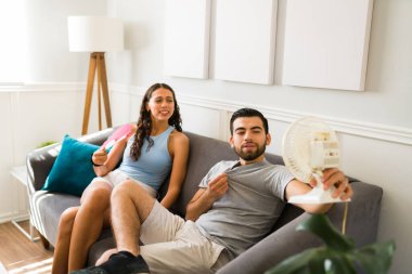 Kliması olmayan seksi çift, sıcak bir yaz yüzünden serinlemek için küçük bir vantilatör kullanıyor. 