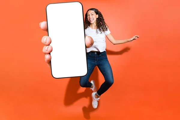 Mulher Brincalhão Pulando Divertindo Mostrar Sua Tela Smartphone Branco Contra — Fotografia de Stock