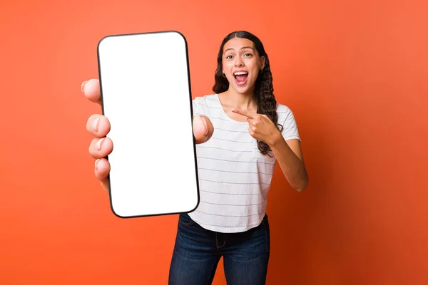 Έκπληκτη Νεαρή Γυναίκα Δείχνει Προς Λευκή Οθόνη Του Smartphone Της — Φωτογραφία Αρχείου
