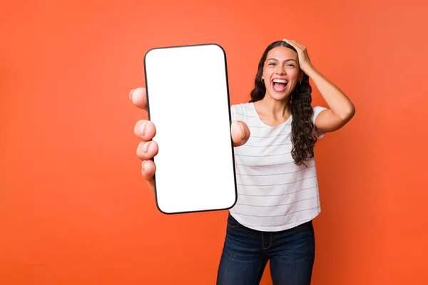 興奮した女性は 彼女の大きなサイズのスマートフォンでモバイルアプリを使用している間 彼女のテキストメッセージを信じることができません — ストック写真