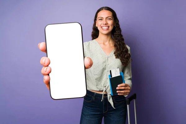 スマートフォンの白い画面を見せるラテン系の魅力的な女性 休暇中に旅行アプリを使用している若い女性 — ストック写真