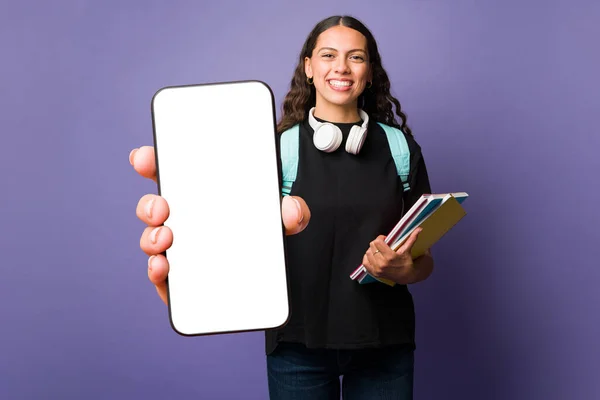 スマホの大きな白い画面を見せながら モバイルアプリを使って宿題をする女子学生 — ストック写真