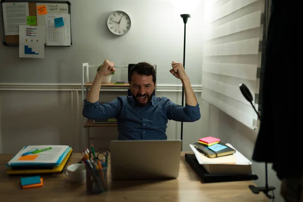 Cheerful Young Man Celebrating Screaming Happiness While Finishing His Work — стоковое фото