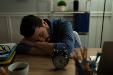 Bir sürü işi olan çekici bir genç adam çalışma masasında uyuyakalıyor. 