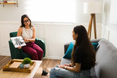 Terapi seansı sırasında depresyondaki genç bir kıza hata testi gösteren Latin terapist.