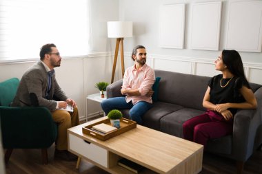 Güzel bir eş ve koca, çift terapisi seansı sırasında koltukta yan yana oturuyor.