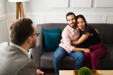 Mutlu İspanyol çift, çiftler terapisinde sorunlarını çözdükten sonra sarılıp pozitif hissediyorlar.