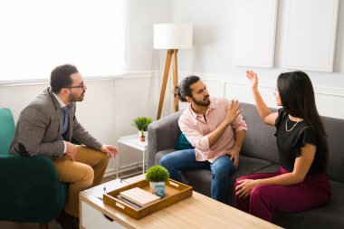 Fiziksel taciz konsepti. Kızgın kadın kavga ediyor ve çiftler terapisi sırasında kocasına vurmaya çalışıyor. 