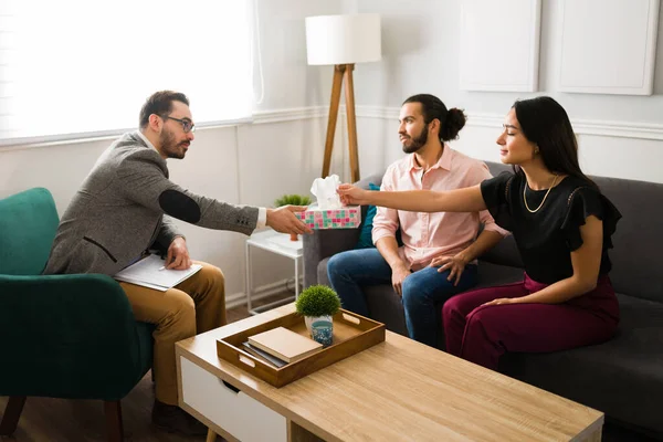Erkek terapist, ağlayan bir kadına mendil uzatıyor. Kocasıyla çiftler terapisinde yaşadığı sorunları anlatıyor.