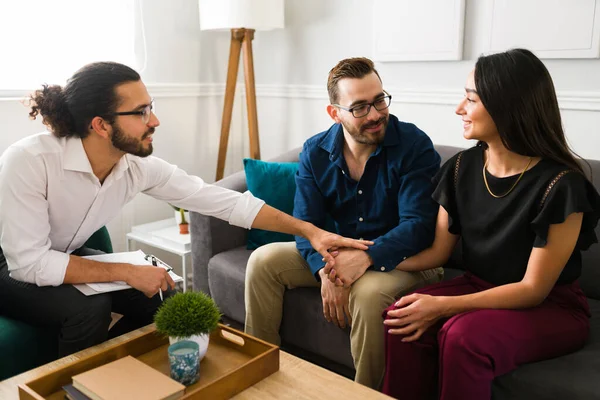 Mutlu evli çift, çiftler terapisi sırasında gülümseyip el ele tutuşurken ilişkilerini çözüyorlar.