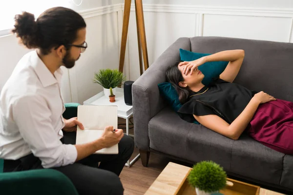疲惫的年轻女人躺在治疗师办公室的沙发上 谈论自己的情感问题 — 图库照片