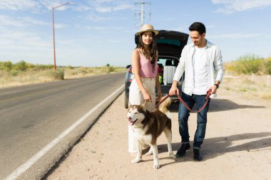 Güzel İspanyol çift yol kenarında köpeğini gezdirirken arabayla tatile çıkıyor.