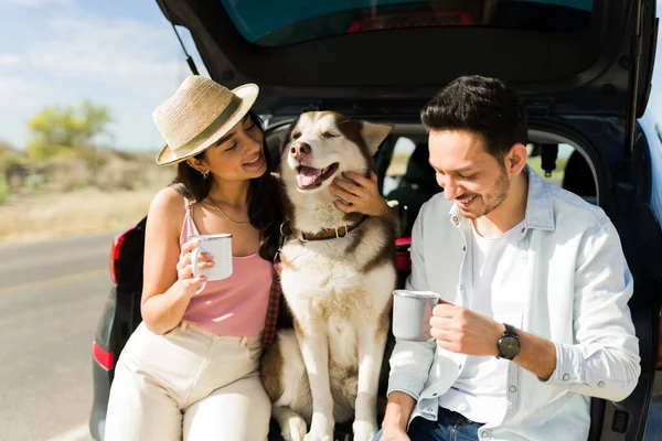 Cheerful Couple Petting Dog Drinking Coffee While Taking Break Car — Stockfoto