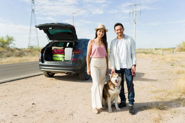 Genç bir çiftin portresi gülümseyen ve hafta sonu boyunca mutlu köpekleri ile yol yolculuğunun keyfini çıkaran