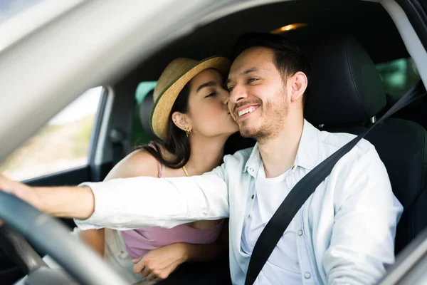 魅力的な若いです女性与えますキスオンザ頬に彼女のボーイフレンドへ運転しながら一緒に休暇 — ストック写真