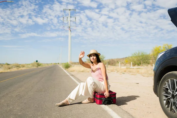 Yolda kalmış genç bir kadın yolda oturuyor ve arabası bozulduktan sonra yardım istiyor.