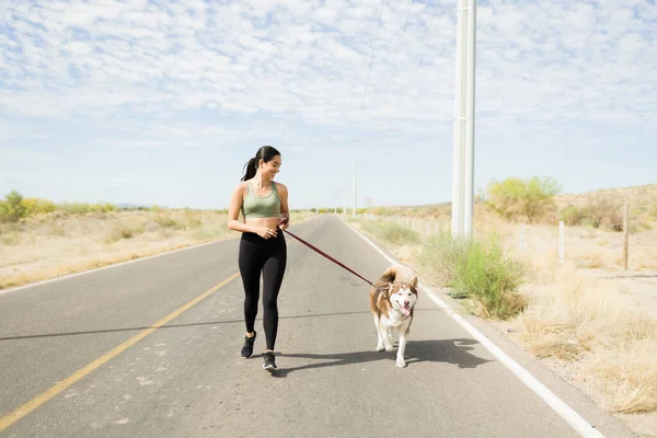 Excited Fit Woman Laughing While Running Deserted Road Her Husky — Stockfoto