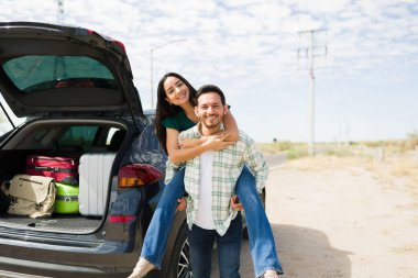 Çekici bir genç adamın portresi bir araba yolculuğu sırasında yol kenarında duran bir kadını sırtında taşıyor.