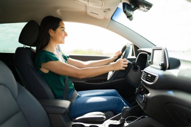 Happy attractive woman smiling and enjoying driving her car during a long trip 