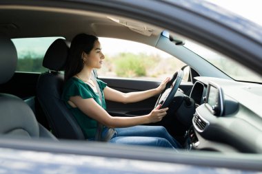 Arabasını yolda kullanan Latin bir kadının profili. Genç bir kadın bir arkadaşıyla buluşmaya gidiyor.