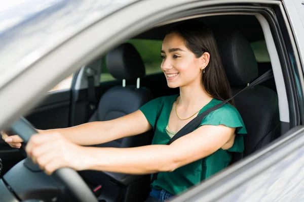 一人で運転しながら笑っている美しいラテン語の女性 陽気な女が車の後ろに — ストック写真
