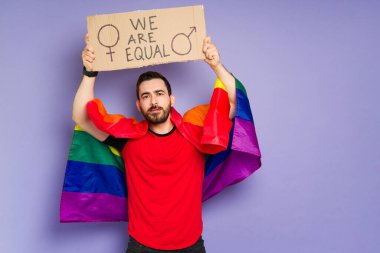 LGBT yürüyüşünde gey haklarını ve cinsiyet eşitliğini destekleyen gökkuşağı bayraklı çekici eşcinsel adam. 