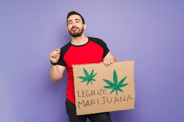 Neşeli genç adam marihuana içiyor ve esrarı yasallaştırmak için bir protestoya katılıyor 