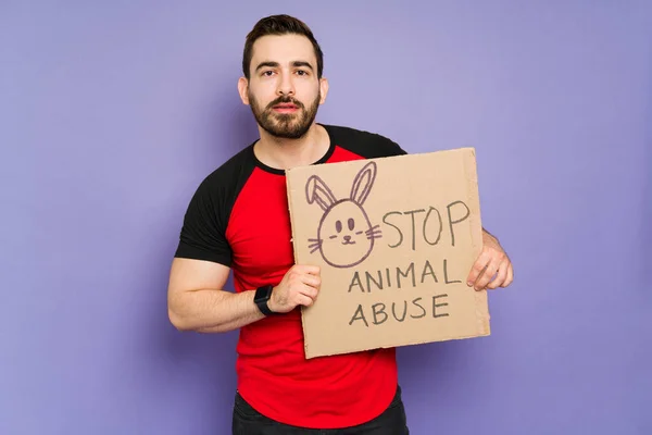 Caucasian attractive man protesting against animal cruelty and asking the cosmetic industry to stop animal abuse