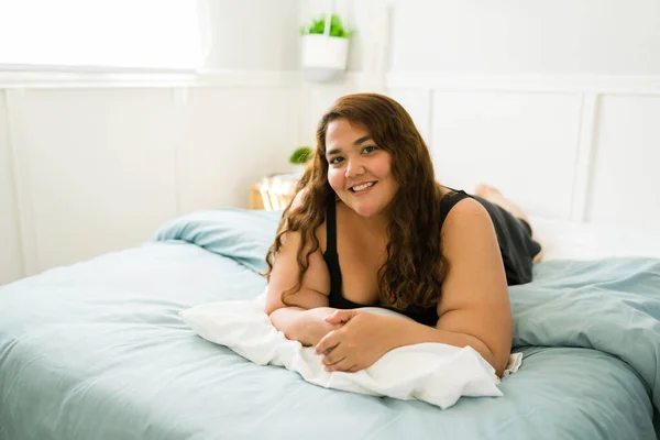 Neşeli Genç Bir Kadın Rahat Bir Yatakta Karnının Üstünde Uzanıyor — Stok fotoğraf