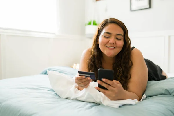 Ενθουσιασμένη Νεαρή Γυναίκα Στο Κρεβάτι Χρησιμοποιώντας Smartphone Της Και Πληρώνοντας — Φωτογραφία Αρχείου