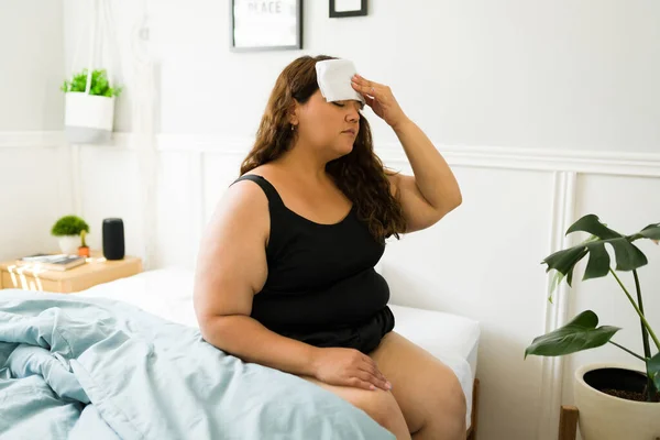 Латиноамериканская Женщина Ожирением Чувствует Себя Больной Лихорадкой Надевая Холодное Полотенце — стоковое фото