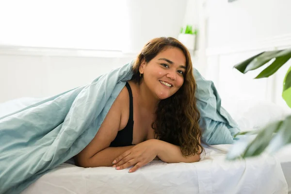 여자가 침대에 침대에서 여가를 즐기면서 미소짓는다 — 스톡 사진