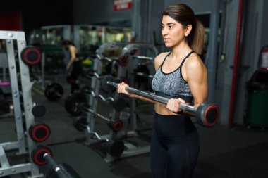 Güzel İspanyol kadın spor salonunda ağırlık kaldırıyor. Spor antrenörü spor yapıyor. 